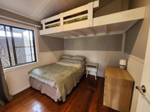 a small bedroom with a bed and a loft at Hillside Hideaway - Your Base for the Region in Cawongla