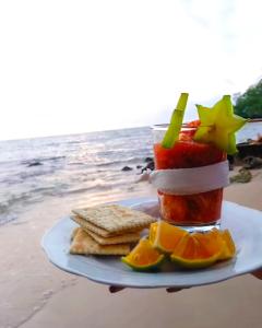 a plate with a drink with fruit and crackers on the beach at Cabañas Isla Bonita in Puerto Limón
