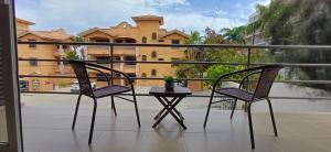 two chairs and a table on a balcony with a building at Condo Sunset in Cabo San Lucas