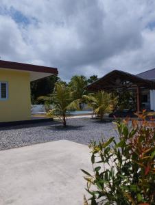 a house with palm trees and a building at Dom's Oase in Panglao Island