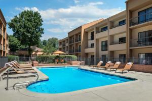 a swimming pool with lounge chairs next to a building at Courtyard Virginia Beach Norfolk in Virginia Beach