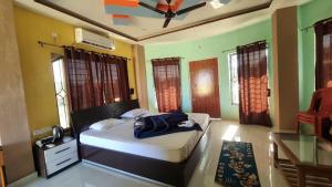 a bedroom with a bed and a table and windows at North Queen in Lataguri