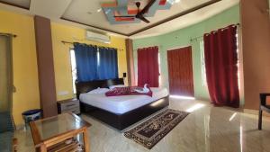 a bedroom with a bed and red curtains at North Queen in Lataguri