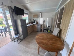 a kitchen with a wooden table and a dining room at Petit chalet cosy house in Hermanville-sur-Mer
