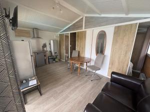 a living room with a table and a kitchen at Petit chalet cosy house in Hermanville-sur-Mer