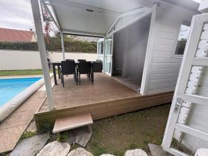 a screened in porch with a table and chairs at Petit chalet cosy house in Hermanville-sur-Mer