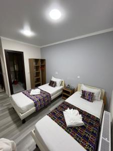 a hotel room with two beds and a mirror at Ichan Kala Silk Road Guest House in Khiva
