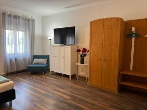 a living room with a tv on top of a cabinet at Familienferienhaus Amelie in Mörbisch am See