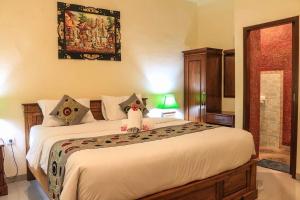 a bedroom with a bed with a stuffed animal on it at Reynold Artha Guest House in Nusa Lembongan