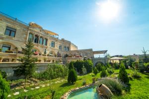 a large building with a garden in front of it at Goreme Inn Hotel Only Adult in Göreme
