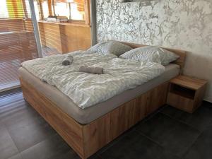 a large bed with a wooden frame in a bedroom at MAX apartmán jazero in Trstice