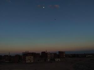 a city skyline at dusk with the moon in the sky at عقار محمد سعيد عجوة in Abū Kabīr