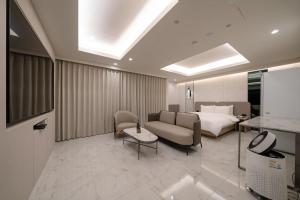 a hotel room with a bed and a couch at 르벤토 호텔 in Jūrin-ri