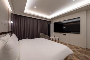 a hotel room with a bed and a flat screen tv at 르벤토 호텔 in Jūrin-ri +38 photos