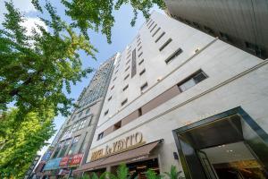 a tall building with a sign for a hotel at 르벤토 호텔 in Jūrin-ri
