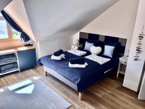 a bedroom with a blue bed with towels on it at Bálics Vendégház in Pécs +43 photos