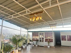 a large room with a balcony with plants and lights at Hotel Mount View in Haldwāni