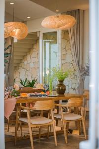 a dining room with a wooden table and chairs at La Brise in Ấp Khánh Phước (1)