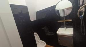 a bathroom with a sink and a toilet and a mirror at Little Susie Double Room with Balcony in Phnom Penh