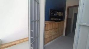 a door to a room with a television in a room at Little Susie Double Room with Balcony in Phnom Penh
