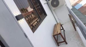 a room with a chair and a window and a fan at Little Susie Double Room with Balcony in Phnom Penh +4 photos