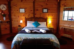 a bedroom with a bed in a log cabin at Pelicans at Denmark in Denmark