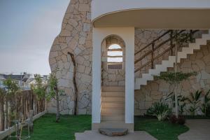 a house with a stone wall and a staircase at La Brise in Ấp Khánh Phước (1)
