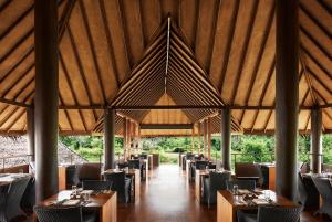 a dining room with tables and chairs and a roof at Jetwing Vil Uyana, A Luxury Reserve in Sigiriya