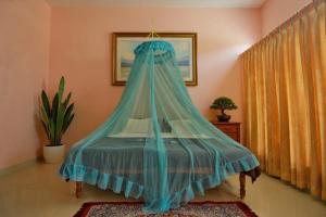 a bed with a blue canopy in a room at Hotel Cocobeach Kovalam in Kovalam