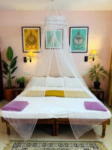 a bed with a net on it in a room at Hotel Cocobeach Kovalam in Kovalam