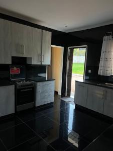 a kitchen with white cabinets and a stove top oven at Indolo Home in Bulawayo