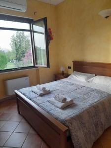 a bedroom with a large bed with towels on it at Agriturismo Le Panizze in Centenaro