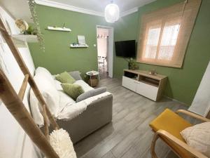 a living room with a couch and a tv at Sea Breeze Alojamientos in Barbate
