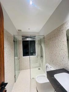 a bathroom with a shower and a toilet and a sink at Changvilla Đông Hải in Thôn Ðông Giang
