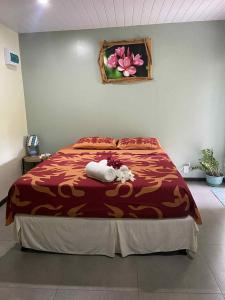ein Schlafzimmer mit einem Bett mit roter Bettdecke in der Unterkunft Fare anuhe in Bora Bora