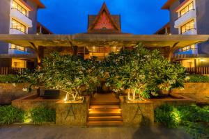 a building with trees in front of it at night at Ayrest Hua Hin Hotel in Hua Hin