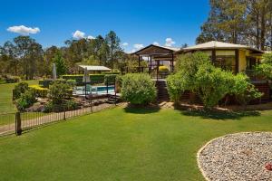 a house with a fence and a yard with a pool at Firefly Resort in Firefly