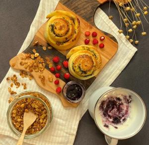a table topped with pastries and berries on a cutting board at ECO River Camp - Pitches in Radovljica
