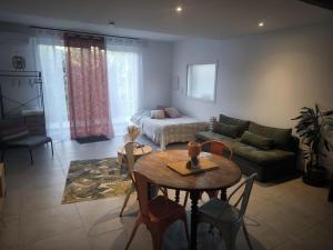 a living room with a table and a couch at Studio meublé Rosieres in Rosières