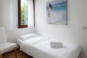 a bedroom with two beds and a painting on the wall at Villa Riviera by the Sea in Lignano Sabbiadoro