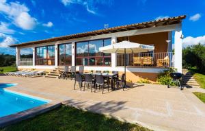 a villa with a patio and a swimming pool at Sa Font Den Ros in Son Servera