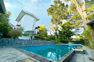 a swimming pool in front of a house at Ilamperuma Bungalow in Weligama