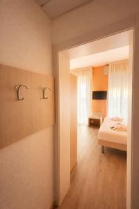 a bedroom with a bed and a room with a window at Hotel Villa Trieste in Sirmione