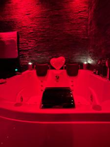 a red bathtub in a room with red lighting at Le souffle de l’amour in Melun +1 photo