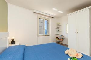 a bedroom with a blue bed and a window at Appartamento La terrazza in Baunei