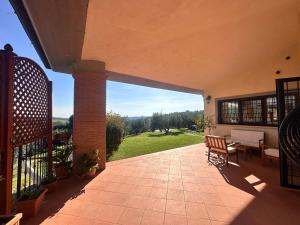 a large patio with a view of a green field at Linda's Retreat in Fiano Romano