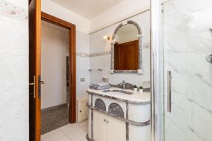 a bathroom with a sink and a mirror and a shower at Appartamento La terrazza in Baunei +37 photos