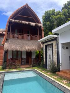 a villa with a swimming pool in front of a house at Villa Lumbung sari in Badung