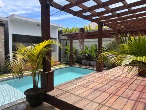 a swimming pool in a backyard with a pergola at Villa Lumbung sari in Badung