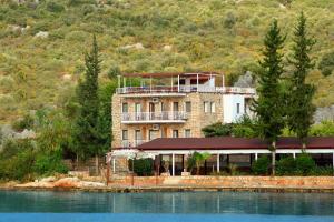 ein großes Gebäude an der Seite eines Wasserkörpers in der Unterkunft Baba Veli Pension in Kaleucagız